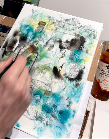 painting process with a bottle of Talisker whisky on a table.